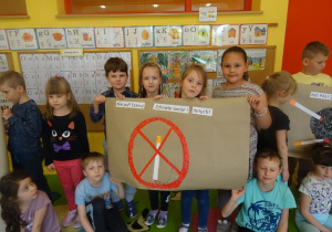 Dzieci prezentują plakat na temat szkodliwości palenie tytoniu.